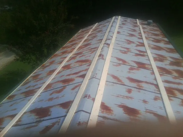 Rusted metal roof panels with new wood purlins before replacement — Storm Damage Roof Repair in Eubank by Roofing Brothers