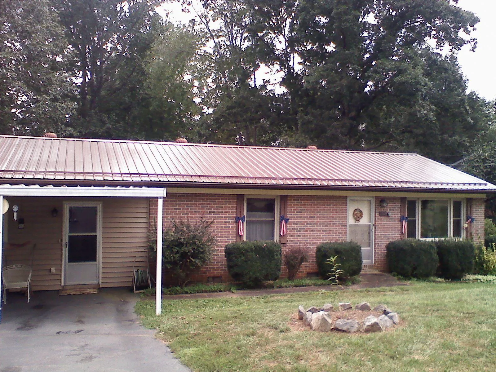 Bronze metal roof and carport on a brick ranch home — Roof Repair work by our crew in Eubank